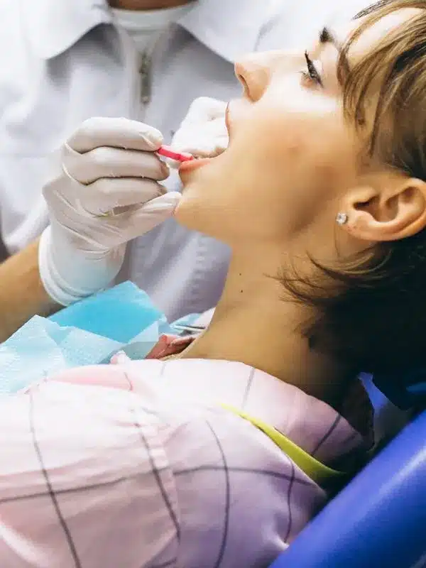 Dentist examining patient's teeth during dental checkup in clinical setting